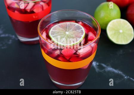 Nahaufnahme ein Glas Rotwein Sangria mit Unwischtes ein Glas und Limes im Hintergrund Stockfoto