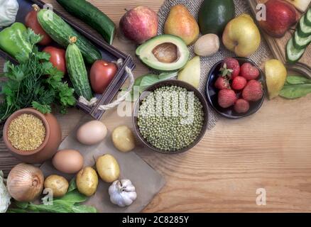 Eine Vielzahl von Bio-Lebensmitteln auf dem Holztisch: Obst, Gemüse, Eier, Getreide, Bohnen mit Sprossen. Das Konzept der gesunden Ernährung. Stockfoto