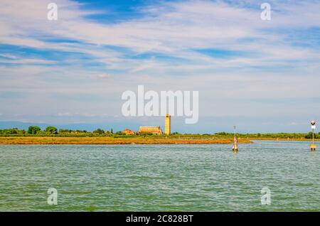 Panoramablick auf die Insel Torcello im Wasser der Lagune von Venedig mit der Kathedrale Santa Maria Assunta Glockenturm campanile und Sumpf. Blick von der Insel Burano. Provinz Venedig, Region Venetien, Norditalien Stockfoto