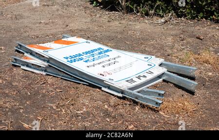 COVID19-SCHILDER FIELEN AUF DEN BODEN. STRASSENSCHILD WARNUNG SOZIALE DISTANZIERUNG. Stockfoto