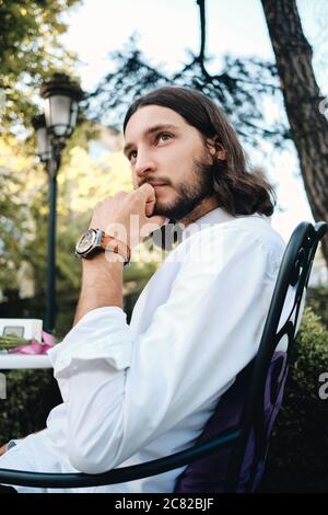Junge attraktive nachdenkliche Brünette bärtigen Mann im Hemd nachdenklich Blick weg in Café Stockfoto