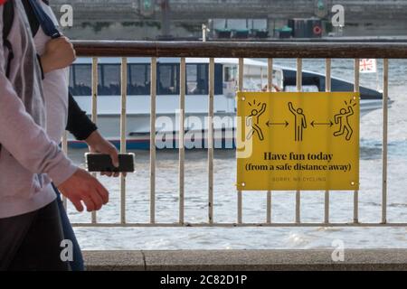 London, Großbritannien. Juli 2020. Schilder zu „Hab heute Spaß haben, aus sicherer Entfernung“ erinnern die Londoner an die neuen Regeln. An vielen öffentlichen Orten in London gibt es Schilder, die sich auf 2 Meter Entfernung halten, aber die Regeln werden nicht immer eingehalten, da viele Menschen die Entspannung der Absperrung und Geselligkeit bei warmem Wetter genießen. Kredit: Imageplotter/Alamy Live Nachrichten Stockfoto