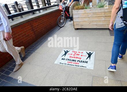 London, England, Großbritannien. COVID-19 Vorsichtsmaßnahmen auf der Südbank. Schilder, die soziale Distanzierung und kein Radfahren - Radfahrer ignorieren die Schilder Stockfoto