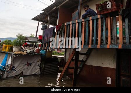 Ein Bewohner steht von seinem Balkon, als der Bagmati-Fluss nach den Monsunregen in Kathmandu überfloss.die durch Monsun verursachten Katastrophen haben am Montag 114 Menschenleben gefordert, während Hunderte von Haushalten im ganzen Land vertrieben wurden. Mehrere von Katastrophen heimgesucht Gebiete wurden abgeschnitten, wie Überschwemmungen und Erdrutsche haben weg Brücken und Straßenabschnitte auf einigen Autobahnen. Stockfoto