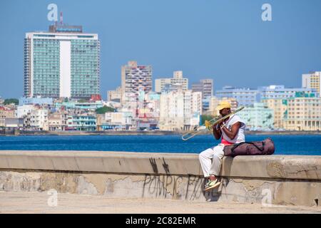 Ein Straßenmusiker spielt die Posaune an der berühmten Malecon-Mauer am Meer in Havanna Stockfoto
