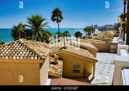 Malaga, Spanien - 01. September 2015: Wenige ähnlich aussehende Schuppen Haus neben Strand vor Palmen in Costa del Sol Occidental ist ein Comarca in Stockfoto