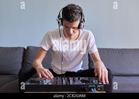 Kreative Teenager Junge in Kopfhörer mit Mixer Ausrüstung Unterhaltung dj Station Stockfoto