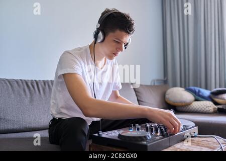 Kreative Teenager Junge in Kopfhörer mit Mixer Ausrüstung Unterhaltung dj Station Stockfoto