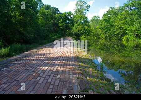 Fußweg entlang des Delaware und Raritan Canal am Colonial Park. Dieser Abschnitt des Weges ist mit Ziegelsteinen gepflastert, die in parallelen Linien angeordnet sind. -02 Stockfoto