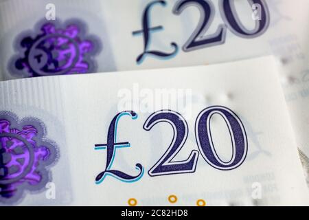 Makrofoto von britischen Pfund Sterling Banknoten. Ecken von 20 Pfund-Noten. Nahaufnahme mit sichtbarem britischen Pfund-Symbol und Hologramm, Stockfoto