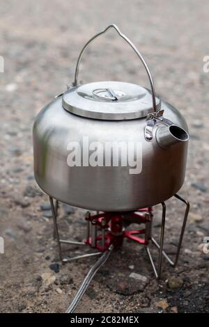 Aluminium-Wasserkocher auf Gasbrenner für draußen Tee auf der Straße Stockfoto