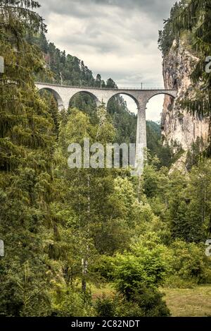 Landschaft mit Landwasserviadukt, Filisur, Schweiz. Landschaftlich schöne vertikale Ansicht der hohen Eisenbahnbrücke in den Alpen. Schöne Schweizer Natur, Landschaft von Alpin Stockfoto