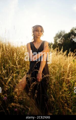 Hübsche Frau, die im hohen Gras steht Stockfoto