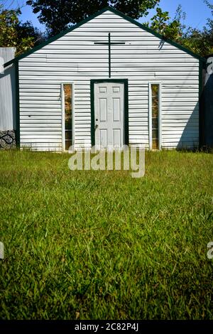 Ein grasbewachsener Vordergrund, eine gefälschte Kirche in Fake Town, ein von Mayberry inspirierter Kunstinstallationskomplex, im ländlichen mittleren Tennessee, USA, Stockfoto