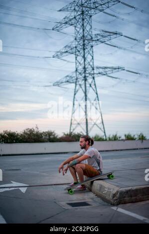 Junge posiert mit Skateboard in der Hand Stockfoto