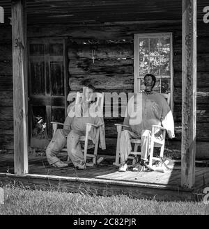 Ein männlicher und weiblicher Schaufensterpuppenkopf mit ausgestopften Körpern in Schaukelstühlen auf der Veranda der gefälschten Hütte in Fake Town, im ländlichen mittleren TN, USA, Stockfoto