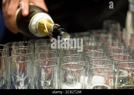 Barkeeper in Gläser gießen Champagner auf einer Party. Stockfoto