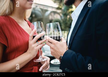 Nahaufnahme junge attraktive Paar mit Gläsern Wein feiert Engagement zusammen im Restaurant im Freien Stockfoto