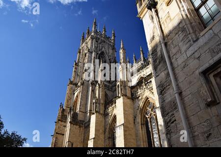 Blick nach oben auf die Westtürme von der Südseite des York Minster. Die Steinarbeiten Details sind zu sehen, die den gotischen Stil zeigen. York, Großbritannien Stockfoto