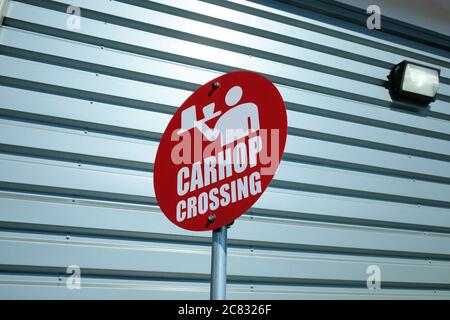Rotes CarHop-Überkreuzungszeichen mit Symbol eines Servers mit einem Tablett, Getränken und Essen außerhalb eines Antriebs durch an einem Sonic Antrieb im Schnellimbisrestaurant. Stockfoto