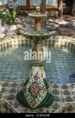 Ein gefliester Brunnen mit bemalten Fröschen aus Keramik auf dem Gelände des Mayaland Hotel in Chichen Itza, Yucatan, Mexiko. Stockfoto