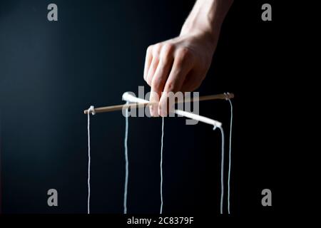 Die Kontrolle über den Geist, verdrehte Sticks mit Seilen in der Hand, Puppentheater Konzept, isoliert Stockfoto