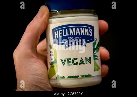 ANTWERPEN, BELGIEN - 15. Nov 2019: Hand hält Hellmanns Vegane und pflanzenbasierte Mayonnaise auf schwarzem Hintergrund. Stockfoto