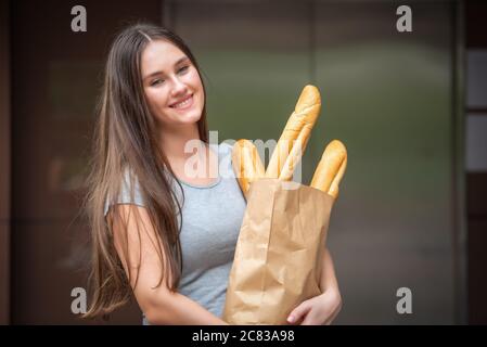 Frau, die das Paket von der Lieferfirma zu Hause erhält. Lieferung und Einkauf online Konzept. Stockfoto