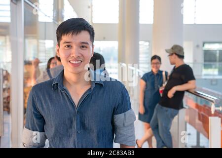 Portrait von jungen und schönen Studenten lächeln mit Freunden auf dem Campus. Casual Outfit der asiatischen männlich in der Schule. Stockfoto