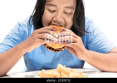 Asiatischer Mann, der einen Hamburger auf weißem Hintergrund isst Stockfoto