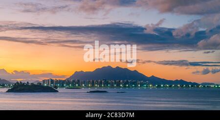 Sonnenuntergang-Foto mit Camburi Strand und den Mata da Praia Gebäuden mit dem Mestre Alvaro Berg im Hintergrund. Stockfoto