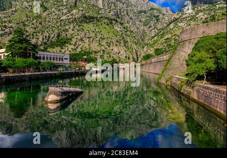 Smaragdgrüne Wasser der Bucht von Kotor oder Boka Kotorska, Berge und das alte steinerne Stadtmauer von Kotor ehemalige venezianische Festung in Montenegro Stockfoto