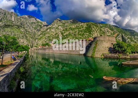 Smaragdgrüne Wasser der Bucht von Kotor oder Boka Kotorska, Berge und das alte steinerne Stadtmauer von Kotor ehemalige venezianische Festung in Montenegro Stockfoto