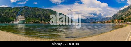 Panorama der Bucht von Kotor mit einem Kreuzfahrtschiff und Berge, die sich im Wasser spiegeln, Balkan an der Adria in Kotor, Montenegro Stockfoto