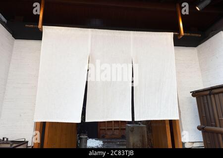 Der Vorhang-ähnliche Stoff, der vor traditionellen japanischen Restaurants und Geschäften hängt, dient nicht nur als Schild, sondern hat eine größere Bedeutung, Stockfoto