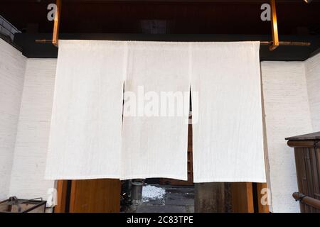Der Vorhang-ähnliche Stoff, der vor traditionellen japanischen Restaurants und Geschäften hängt, dient nicht nur als Schild, sondern hat eine größere Bedeutung, Stockfoto