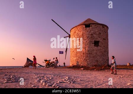 Lefkada, Griechenland. August 2011. Motorradfahrer, die das Meer und den Sonnenuntergang am Strand von Milos, bei der alten Mühle. Stockfoto