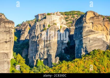 Griechenland. Klarer Sommertag in Meteora. Mehrere Gebäude eines Felsenklosters mit roten Dächern vor wolkenlosem blauem Himmel Stockfoto