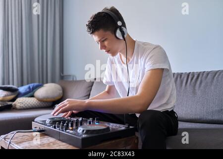 Kreative Teenager Junge in Kopfhörer mit Mixer Ausrüstung Unterhaltung dj Station Stockfoto