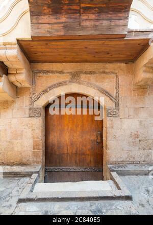 Außen von alten Steinhaus mit verwitterten Wänden und gewölbten Holztür, in der Altstadt Stockfoto