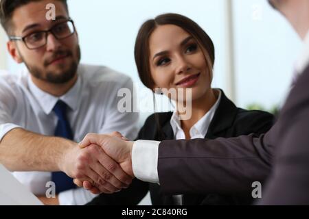 Zwei glückliche Geschäftsleute, die im Büro die Hände schütteln Stockfoto