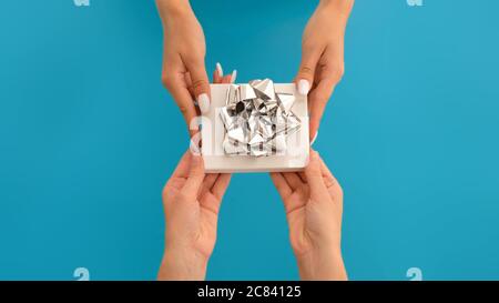 Hände von Menschen mit Geschenkbox Stockfoto