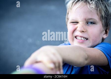 Portrait eines lustigen glücklich schelmisch fröhlich niedlich blonde blauäugige Junge machen Sommersprossen schmutziges Gesicht beim Spielen, lachen. Kindergarten, glückliche Kindheit Stockfoto