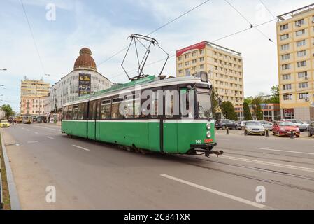 Iasi / Rumänien - 14. Mai 2020: Grüne Straßenbahn mit Fahrgästen, die aus dem Fenster auf die leere Allee schauen Stockfoto