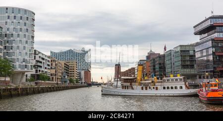 Blick entlang des Sandtorhafens in Richtung Elbphilharmonie. Stadtbild der Hamburger HafenCity mit modernen Gebäuden und Booten. Stockfoto