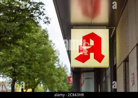 München, Bayern / Deutschland - 6. Juli 2020: Beleuchtetes Apothekenschild. Typisches Logo einer deutschen Apotheke: Ein großes rotes A und das Symbol der Schlange und Ca Stockfoto