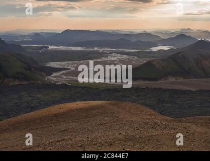 Buntes Rhyolit-Bergpanorma mit Blick auf den Campingplatz Landmannalaugar am Flussdelta. Sonnenaufgang im Fjallabak Nature Reserve, Highlands Island Stockfoto