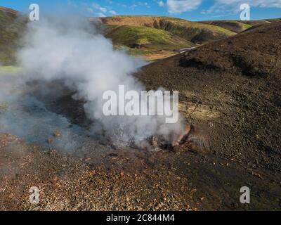 Heisse Quelle mit kochendem Wasser, das aus den Felsen steigt in Landmannalaugar bunte Rhyolit Berge auf dem berühmten Laugavegur Trek. Fjallabak Nature Reserve in Stockfoto