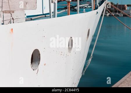 Kleine Bullaugen eines weißen Fischerbootes, die am Hafen am Mittelmeer festgemacht sind (Pesaro, Italien, Europa) Stockfoto