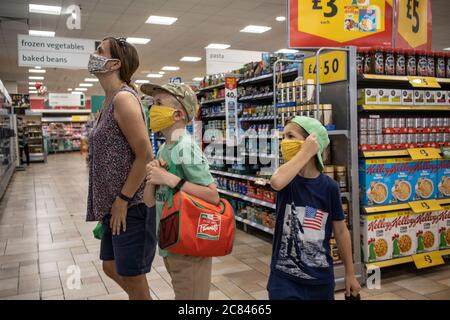 Einkaufen in der Familie in Morrisons UK Supermarkt tragen schützende Gesichtsmaschen gegen die Ausbreitung der Infektion von Coronavirus, London, England Großbritannien zu schützen Stockfoto